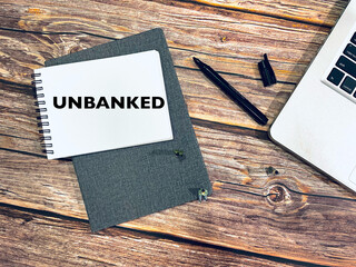 unbanked - notebook, pen and laptop on wooden background