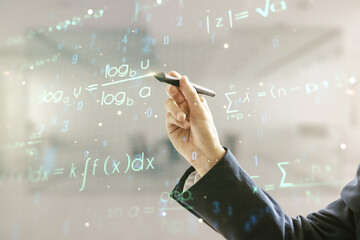 Man hand with pen working with scientific formula hologram on blurred classroom background, research concept. Multiexposure