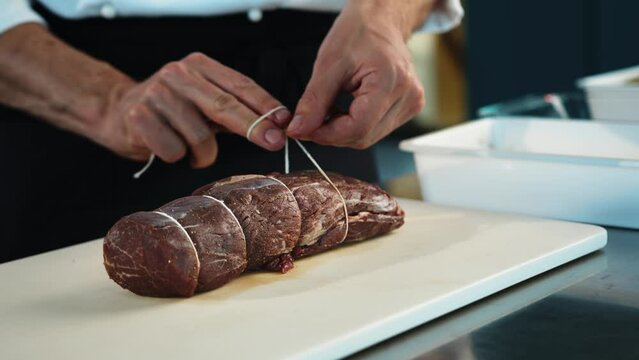 Close-up: The chef cuts the meat of the filet mignon with a knife. The process of preparing food with a restaurant.