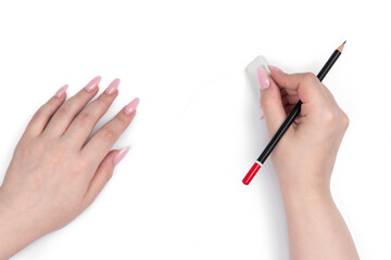 Female hands uses an eraser and black pencil on a white background. File contains a path to isolation.