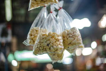 Fresh garlic, peeled, put in plastic bags, hung for sale in Amorn Nakhon Naklua Fresh Food Market, Thailand.