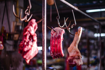 Fototapeta na wymiar Pork hung on iron for sale in Amorn Nakhon Naklua Fresh Food Market, Thailand.