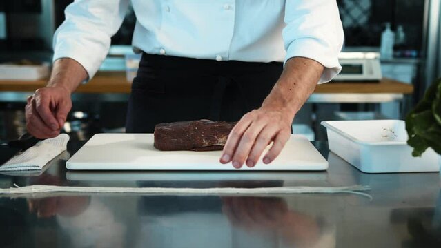 Close-up: The chef cuts the meat of the filet mignon with a knife. The process of preparing food with a restaurant.