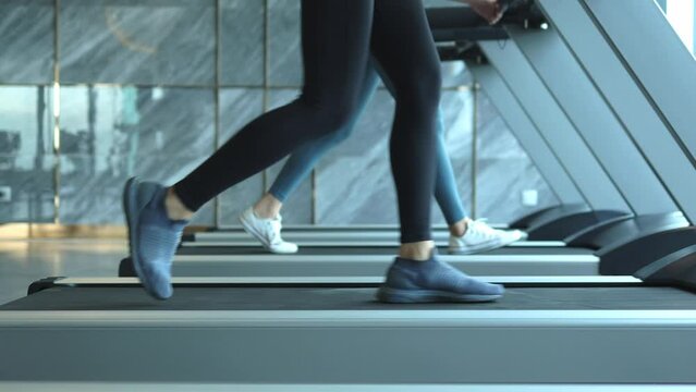 woman exercising on treadmill, Young athletic woman legs jogging on treadmill in hotel sport club slow motion
