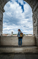 junge Frau mit Rucksack blickt über Arles