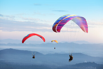 Paragliding in the sky. Paraglider  flying over Landscape sun set Concept of extreme sport, - obrazy, fototapety, plakaty