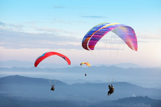 Paragliding in the sky. Paraglider  flying over Landscape sun set Concept of extreme sport,