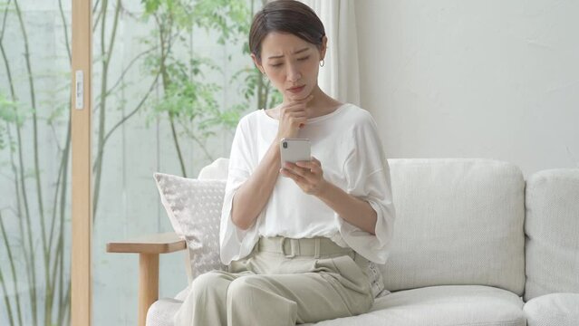 携帯を持ち悩む日本人女性