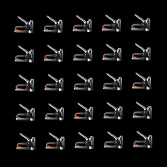 Pattern of construction staplers on a black background. Background for the design.