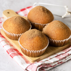 Four Homemade Vanilla Muffins Sprinkled with Icing Cocoa Selective focus