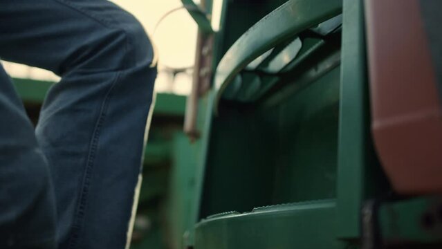 Man legs step tractor ladder sunrise closeup. Farmer go cabin before harvesting