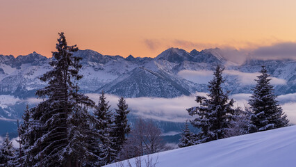 Colorful winter sunset in the Alps, above the inversion and clouds