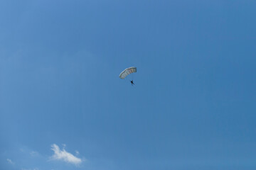 Parasailing in light blue sky. Parachute sports, active leisure, travel, vacation concept. Freedom and active lifestyle