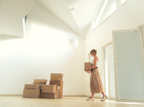 Young Smiling Woman Moving In Her New Modern Apartment