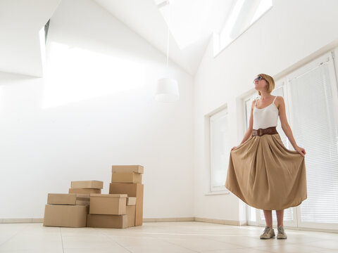 Young Smiling Woman Moving In Her New Modern Apartment