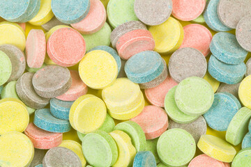 Fototapeta na wymiar Caramelos dulces de colores en forma de pastillas. Vista superior y de cerca