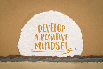 develop a positive mindset inspirational advice - handwriting against abstract paper landscape with a rising sun, positivity and personal development concept