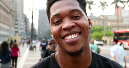 Trendy young black African man smiling at camera in downtown city, real people