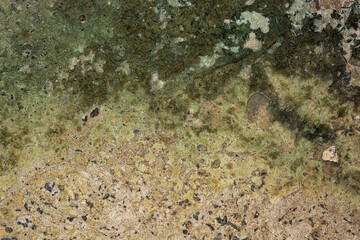 Old cracked concrete with a green tint with traces of copper oxide