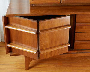 Warm wooden mid-century modern credenza hutch. Close-up view of a vintage sideboard. 
