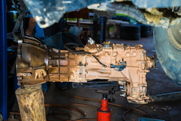 mechanic repairing transmission truck.Off road transmission on hydraulic cylinder crane.