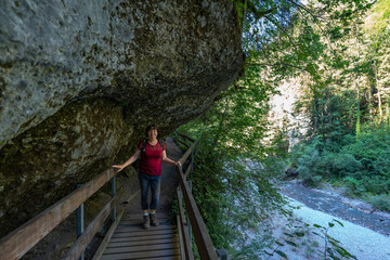 Wanderin in der Bürserschlucht, wandernde Frau neben den steilen Felswänden auf dem schmalen Weg...