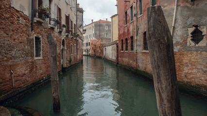 Fototapeta na wymiar Canal with boats and old houses in venice