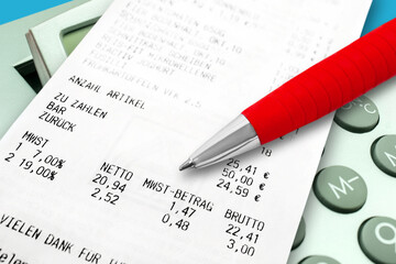 Einkauf und Mehrwertsteuer mit Rechner und roter Kugelschreiber