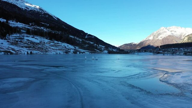 Eisseglen auf dem Haidersee in S&uuml;dtirol im Vinschgau. Drohne hinter einem Eissegler. Gefrorener See 2