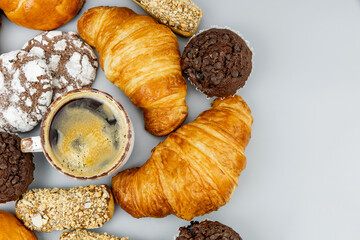Coffee with croissants and other pastries on a light background.
View from above
