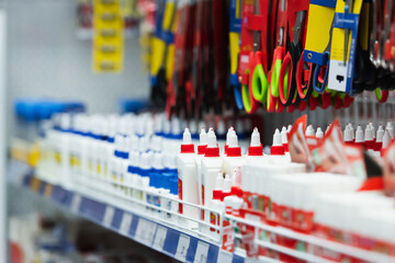 assortment of scissors and glue in stationery shop.