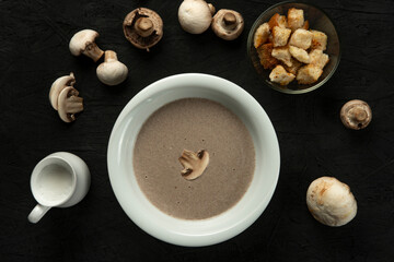 mushroom cream soup in white bowl on black desk