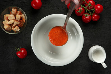tomato cream soup in white bowl on black desk