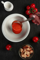 tomato cream soup in white bowl on black desk