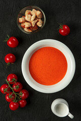 tomato cream soup in white bowl on black desk