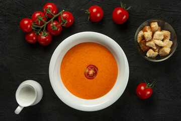 tomato cream soup in white bowl on black desk