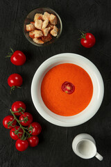 tomato cream soup in white bowl on black desk