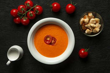 tomato cream soup in white bowl on black desk