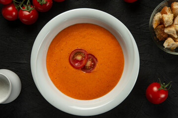 tomato cream soup in white bowl on black desk