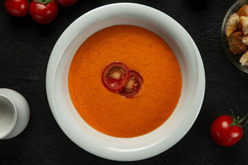 tomato cream soup in white bowl on black desk