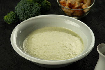 broccoli cream soup in white bowl on black desk