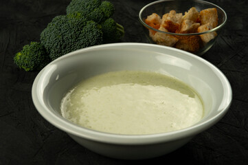 broccoli cream soup in white bowl on black desk