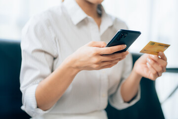girl holding credit card and using phone Online shopping E-commerce Internet banking concept of spending money