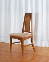 Front view of a charming vintage mid-century dining chair seen in a room with a wooden floor and long white drapes