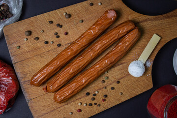 Hunting sausages on a cutting board on a black background. Delicious traditional food