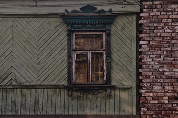 Fototapeta na wymiar Old wooden window in rustic house. Russian folk village architecture. Nalichniki