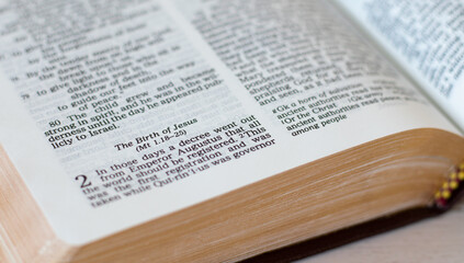 The birth of Jesus Christ, biblical verses in an open Holy Bible Book with golden pages. A closeup....
