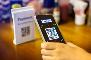 Customer hand using smart phone to scan QR code Tag to accepted generate digital pay without money.