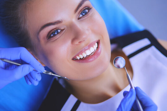 Young Female patient with pretty smile examining dental inspection at dentist office.