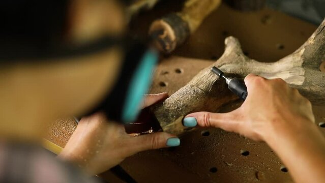 Female using power wood working tools graver, carving while crafting,